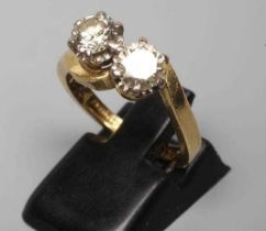 A TWO STONE CROSSOVER DIAMOND RING, the old brilliant cut stones each of approximately 0.50cts, claw