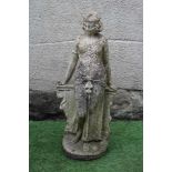 A CAST STONE FIGURE OF AN ODALESQUE modelled standing and leaning against a plinth, 30 3/4" high (