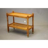 MALCOLM PIPES, AN ADZED OAK TEA TROLLEY of oblong two tier form raised on four square turned faceted