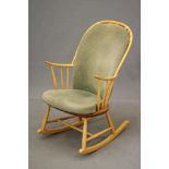 AN ERCOL ROCKING CHAIR, mid 20th century, in blond beech and elm, the hooped spindle back centred by