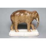 A STAFFORDSHIRE POTTERY MODEL OF JUMBO, the elephant standing on a gilt lined shaped oblong base, 11