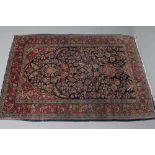 A PERSIAN RUG, 20th century, the navy blue mirhab with vase and flowers, red and ivory floral