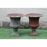 A PAIR OF VICTORIAN CAST IRON URNS of half fluted campana form with everted ovolo rim, waisted socle