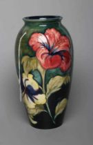 A MOORCROFT POTTERY HIBISCUS PATTERN VASE, mid 20th century, of rounded cylindrical form,