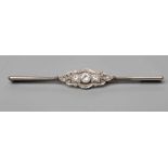 A DIAMOND BAR BROOCH centred by a collet set brilliant cut stone of approximately 0.20cts flanked by