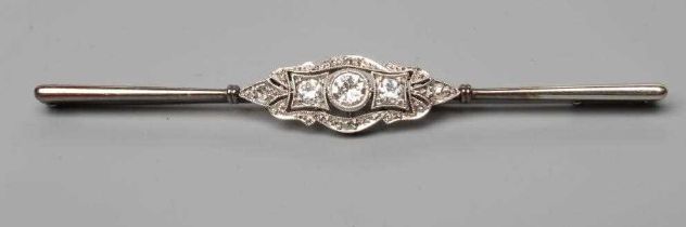 A DIAMOND BAR BROOCH centred by a collet set brilliant cut stone of approximately 0.20cts flanked by