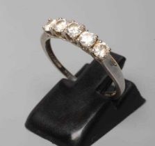 A FIVE STONE DIAMOND RING, the round brilliant cut stones point set to a plain white shank,
