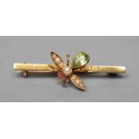 AN EDWARDIAN NOVELTY BAR BROOCH centred by an insect with seed pearl wings and head, ruby cabochon