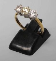 A THREE STONE DIAMOND RING, the central old cut stone flanked by two similar smaller stones