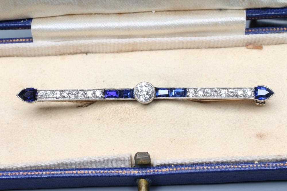 AN ART DECO SAPPHIRE AND DIAMOND BAR BROOCH, the central round brilliant cut stone of