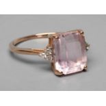 A KUNZITE AND DIAMOND DRESS RING, the oblong cut Kunzite claw set and with three small round