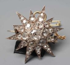 A VICTORIAN DIAMOND STAR BROOCH/PENDANT, the central old cut stone of approximately 0.50cts to an