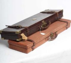 TWO GUN CASES, comprising a leather example, with brass furniture, red interior baize and label