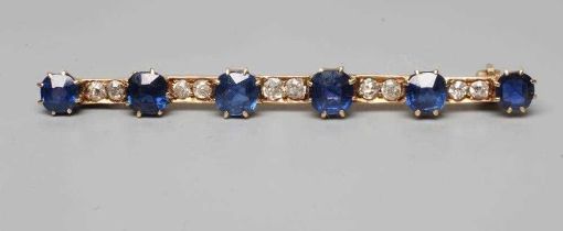 A SAPPHIRE AND DIAMOND BAR BROOCH, the six graduated circular facet cut sapphires claw set to a