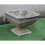 A CAST STONE PLANTER of square form with moulded rim over a band of flower heads, raised on a