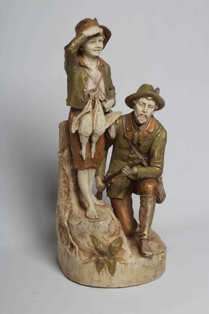 A ROYAL DUX BISQUE PORCELAIN FIGURE GROUP, early 20th century, modelled as a father holding a double