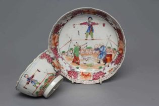 A CHINESE PORCELAIN FAMILLE ROSE TEA BOWL AND SAUCER painted with a tightrope walker and a knife