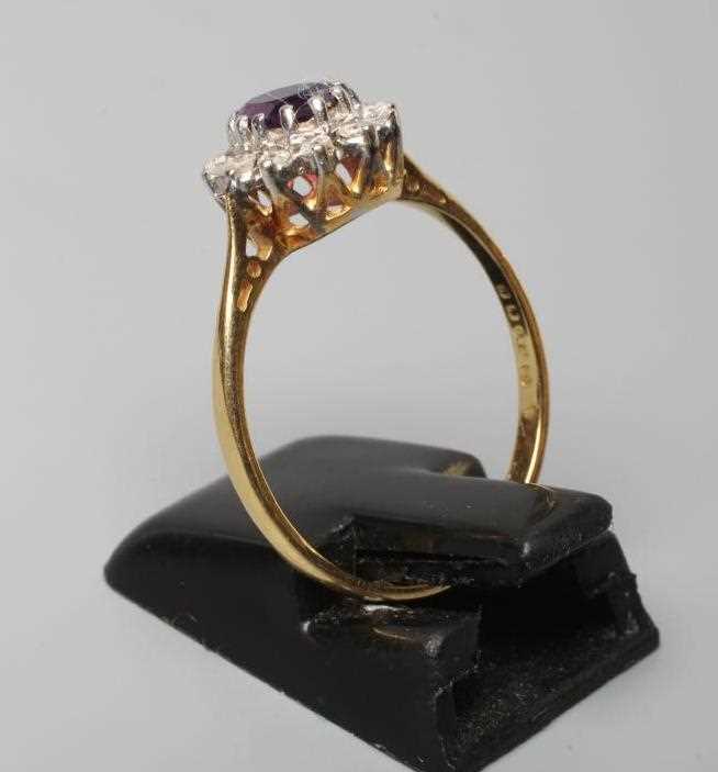 AN AMETHYST AND DIAMOND CLUSTER RING, the oval facet cut amethyst claw set to a border of small - Image 2 of 2