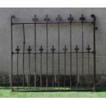 A VICTORIAN CAST IRON GARDEN GATE of two tier barred form with fleur de lys finials and scroll