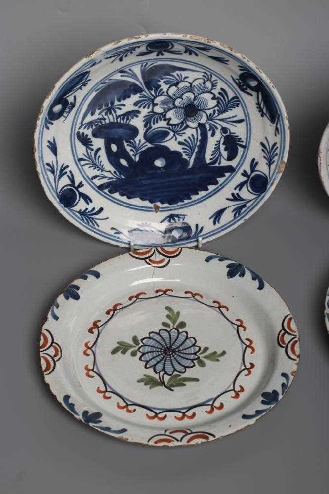 AN ENGLISH DELFT PLATE, London c.1740, painted in green, red, yellow and blue with a seated - Image 2 of 4
