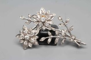 A DIAMOND FLOWER SPRAY BROOCH, the two flowerhead clusters with three leafy branches to an