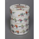 A CHINESE PORCELAIN CYLINDRICAL THREE TIER STACKING BOX AND COVER painted in pastel enamels with