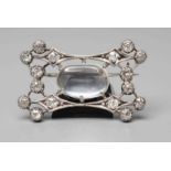 AN EDWARDIAN DIAMOND AND MOONSTONE BROOCH, the open concave oblong panel centred by a claw set
