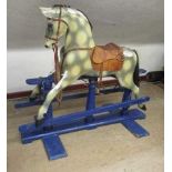 An early 20th century rocking horse, of carved wood construction covered in painted plaster, one