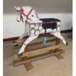 A vintage rocking horse, of wood box construction, with dappled grey paint, fabric saddle and