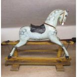 A Victorian rocking horse, of carved wood construction, with mild head tilt, glass eyes, dappled