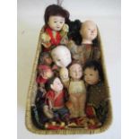 A basket of vintage oriental dolls, comprising four all bisque jointed miniature dolls, three