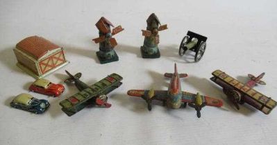 Seven German small tinplate toys comprising three aircraft, two windmills, field gun and garage with