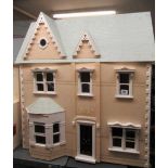 A Victorian style "Dolls House Emporium" dolls house, with two hinged openings revealing seven