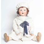 A clockwork Armand Marseille bisque head character doll, with blue glass sideways glancing eyes,