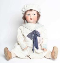 A clockwork Armand Marseille bisque head character doll, with blue glass sideways glancing eyes,