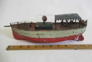 A Carrett clockwork pleasure boat with tin canopy and passengers, clockwork motor tested