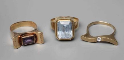 THREE RINGS, one set with a square facet cut aquamarine, the high mount with running figure motif,