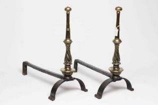 A PAIR OF ARTS AND CRAFTS WROUGHT IRON FIRE DOGS, the brass ring and wrythen turned tapering