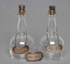 A PAIR OF MINIATURE SILVER MOUNTED GLASS WHISKY DECANTERS and covers, maker Levi & Salaman,