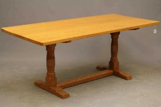 A DAVID LANGSTAFF ADZED OAK DINING TABLE, the rounded oblong top on turned faceted end supports, the