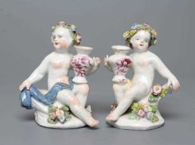 A PAIR OF BOW PORCELAIN PUTTI, c.1760, modelled naked with flower garlands in their hair, seated and