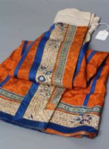 A CHINESE SILK SKIRT PANEL, the burnt orange gores with bright blue seams, with blue and gold thread