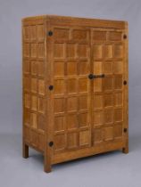 A ROBERT THOMPSON ADZED OAK WARDROBE of oblong multi panelled form with half penny moulded