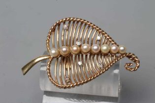 A STYLISED OPEN LEAF BROOCH, the dished wire work panel with rope twist border centrally peg set