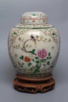 A CHINESE JAR AND COVER of ovoid form, painted in colours with two quatrefoil panels enclosing