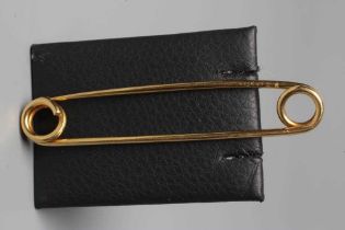 A CARTIER KILT PIN of simple twisted wire with a loop to each end, one forming the clasp, engraved