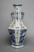 A CHINESE PORCELAIN VASE of swept octagonal form with two scrolling handles, painted in underglaze