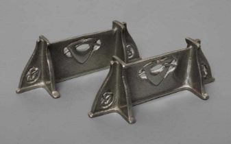 ARCHIBALD KNOX FOR LIBERTY - a pair of pewter knife rests, of oblong form and pierced with