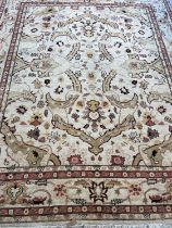A PERSIAN STYLE WOOL CARPET, the ivory ground with all over bold foliate pattern in pale green and