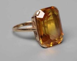 A COCKTAIL RING claw set with an oblong facet cut citrine to a plain, unmarked shank, size N (Est.